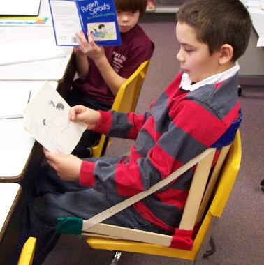 Boy in classroom chair with HowdaSEAT
