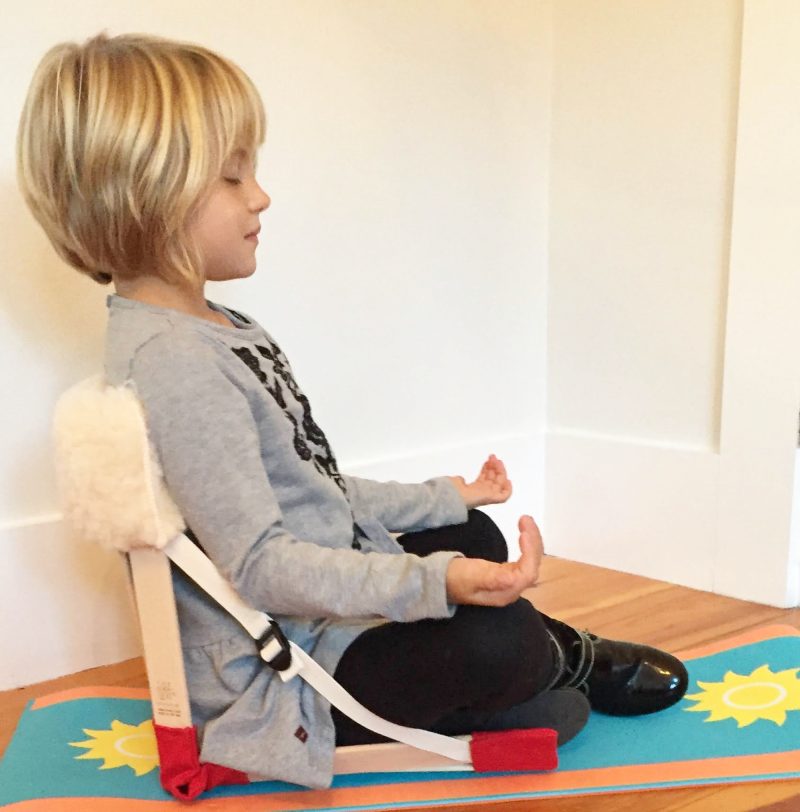 Little girl meditating with HowdaSEAT on floor