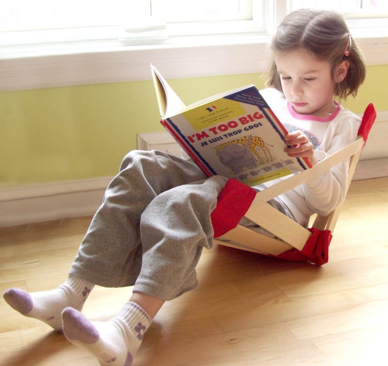 Little girl reading a book in HowdaSEAT