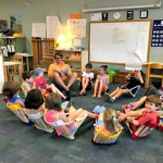 Montessori circle time with kids sitting on the floor in HowdaHUG seats