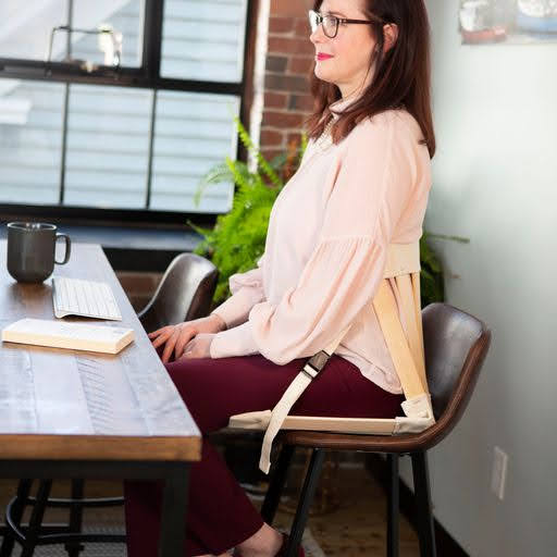 Stylish woman sitting in a HowdaSEAT placed on office chair for extra comfort and support